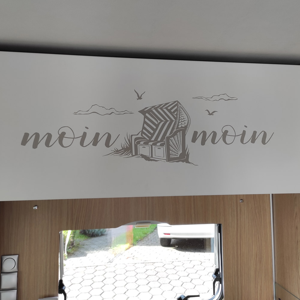 Moin moin mit Strandkorb über einem Fenster im Wohnmobil