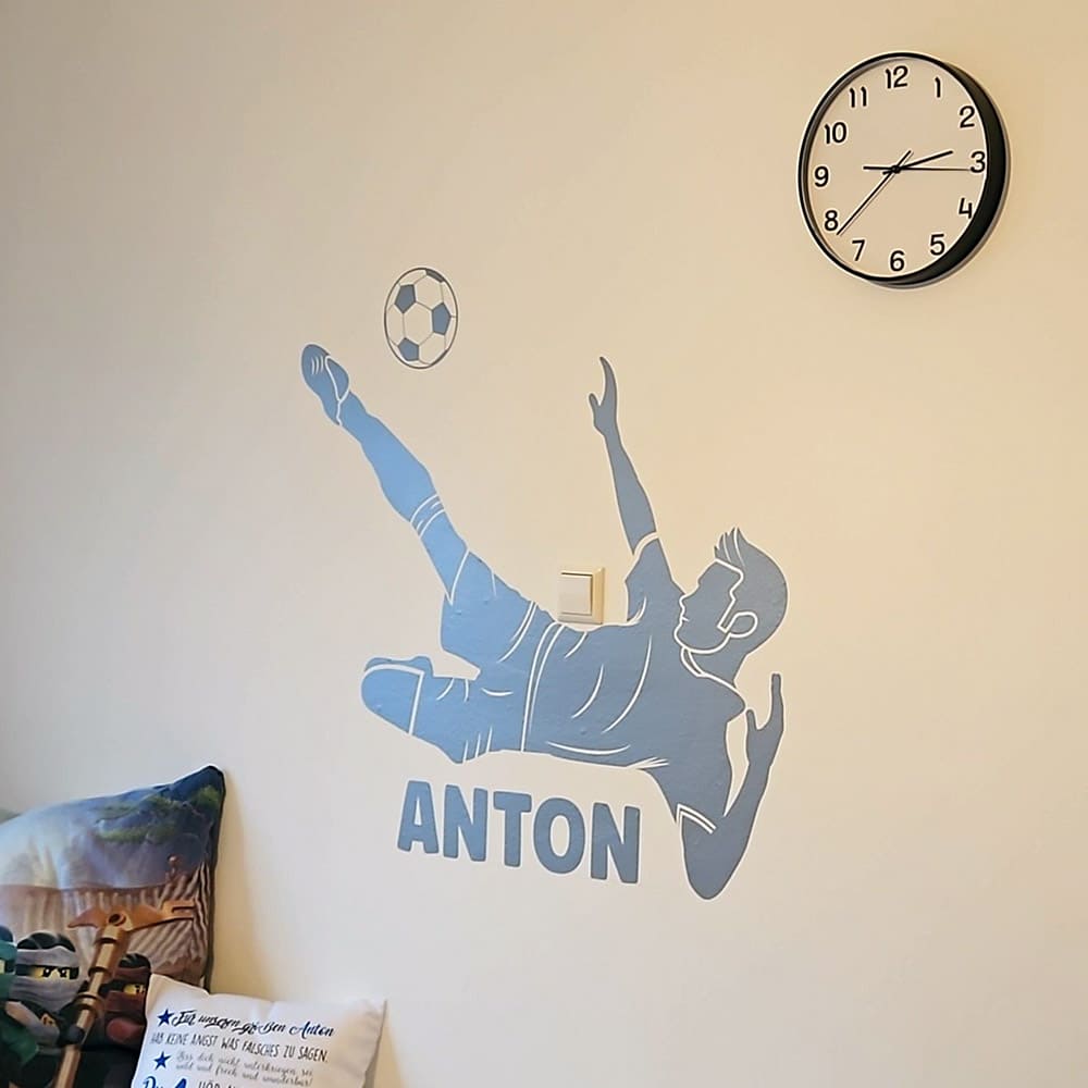Blaues Wandtattoo Fußball Akrobatik mit persönlichem Namen an einer Kinderzimmerwand