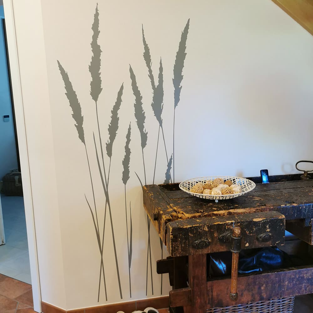 Graue Wandtattoo-Gräser im Flur neben einer alten Holzwerkbank