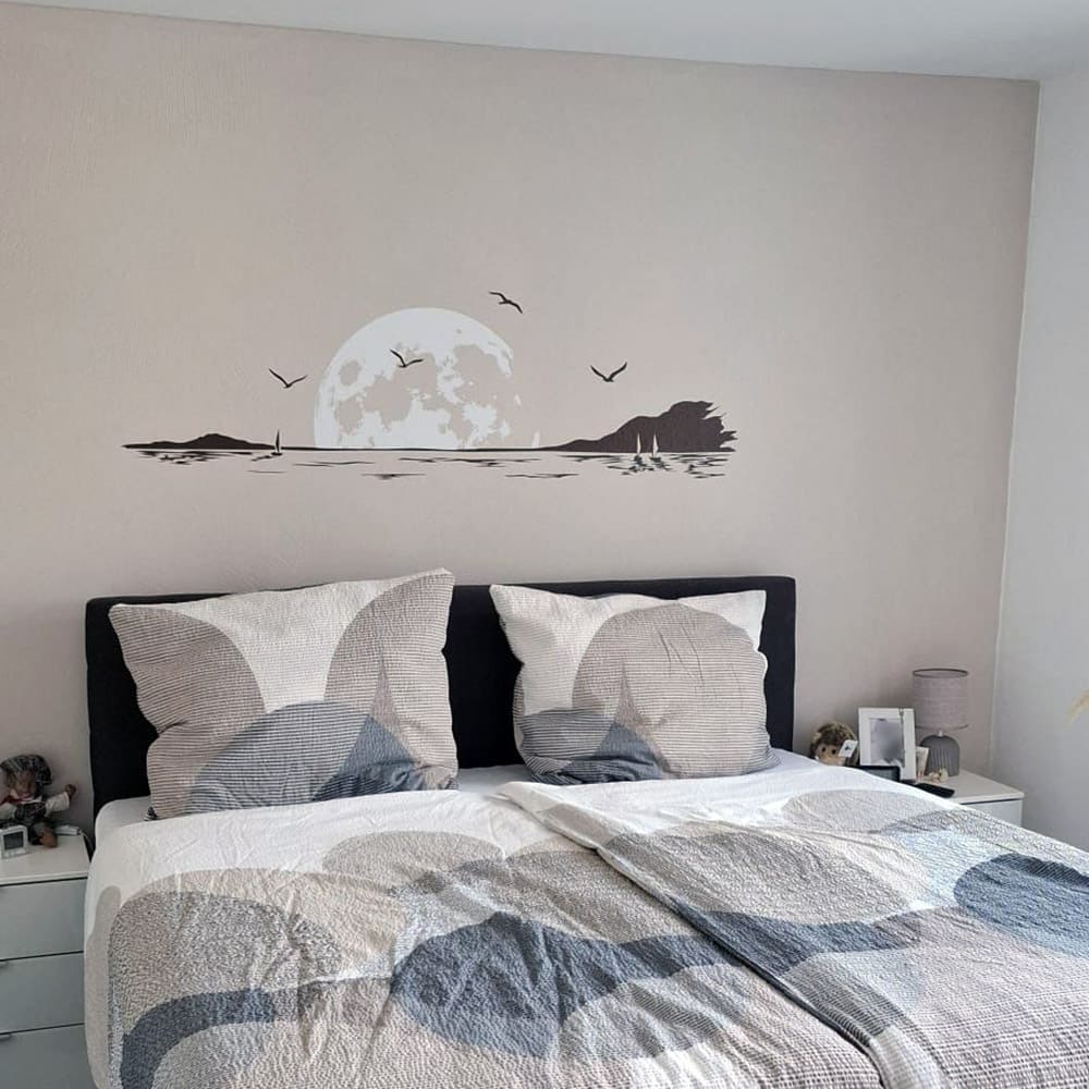 Zweifarbiges Wandtattoo Mondstimmung am Meer über einem Bett